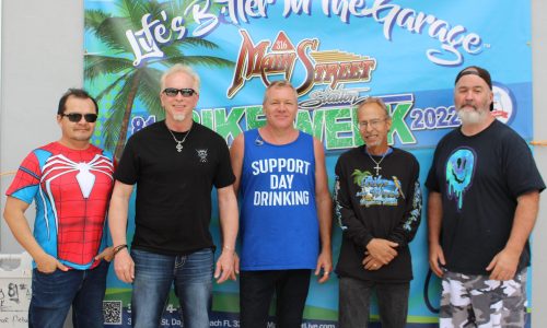 Five men pose in front of a ‘Life’s Better in the Garage’ banner.